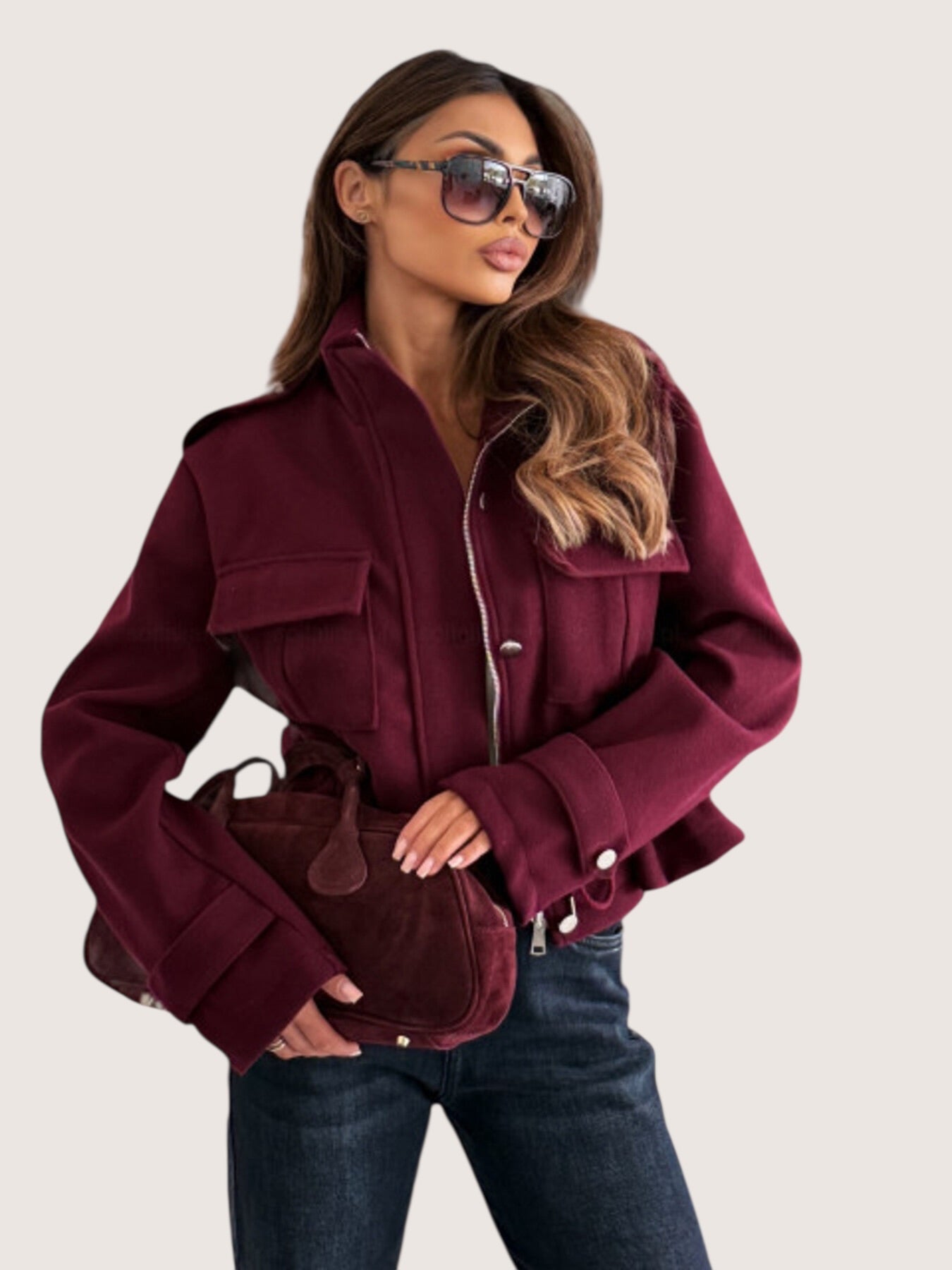 Maroon suede crossbody bag with rounded top handle on Daverri jacket