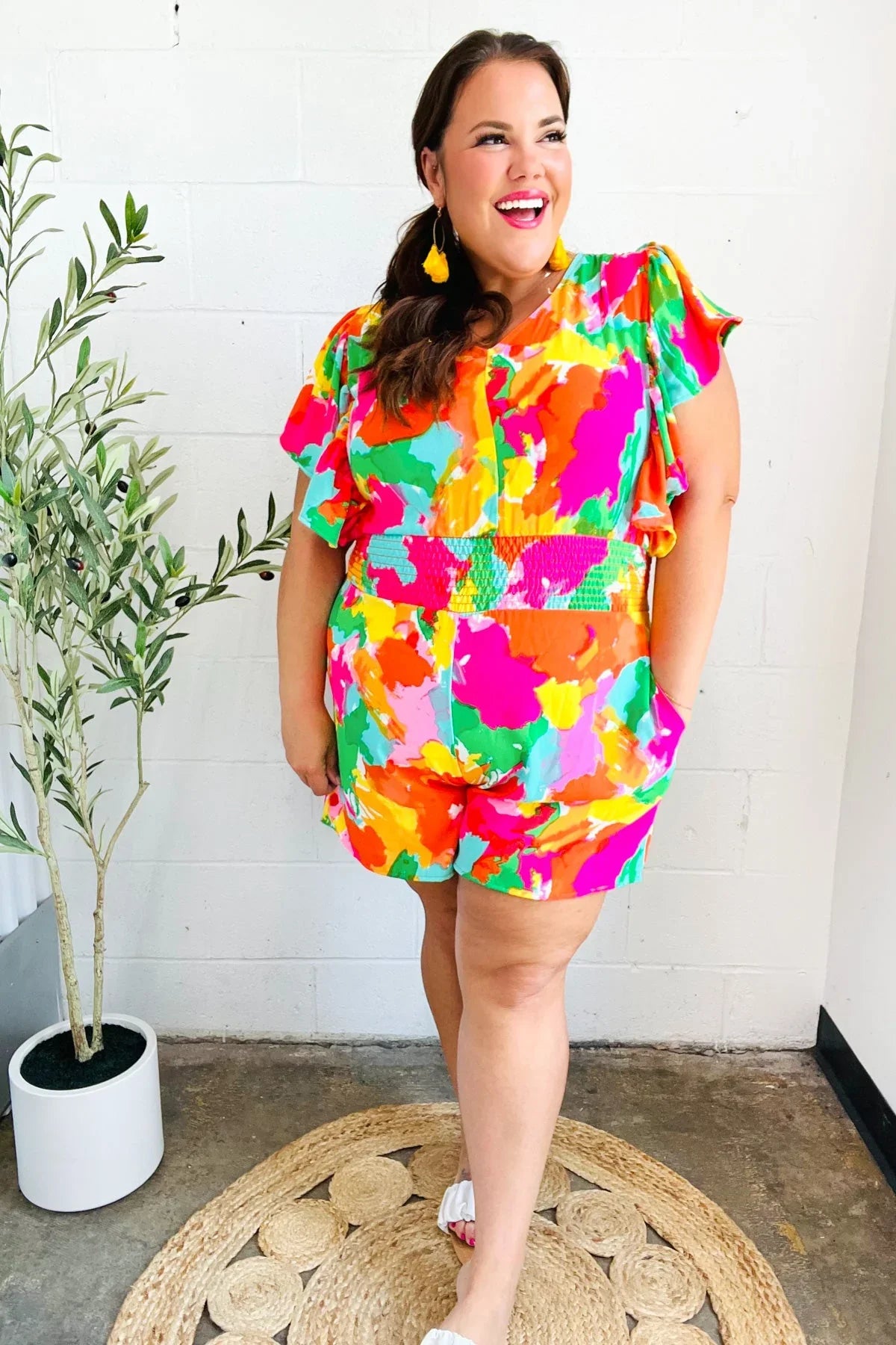 Multicolored abstract floral romper with ruffled sleeves and white sneakers
