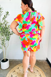 Multicolored abstract floral print romper with smocked waist and flutter sleeves