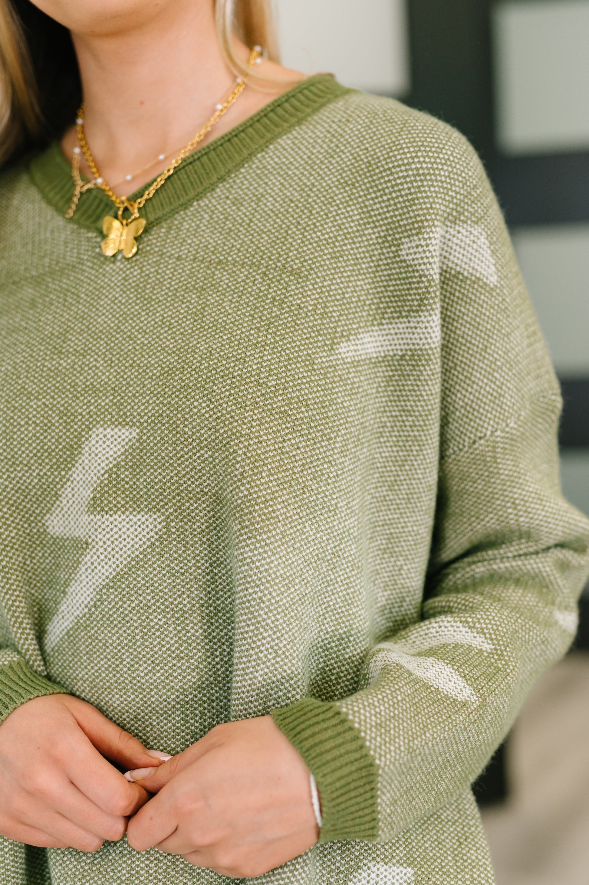 Olive green Shock Value V-neck sweater with white lightning bolt arrow patterns