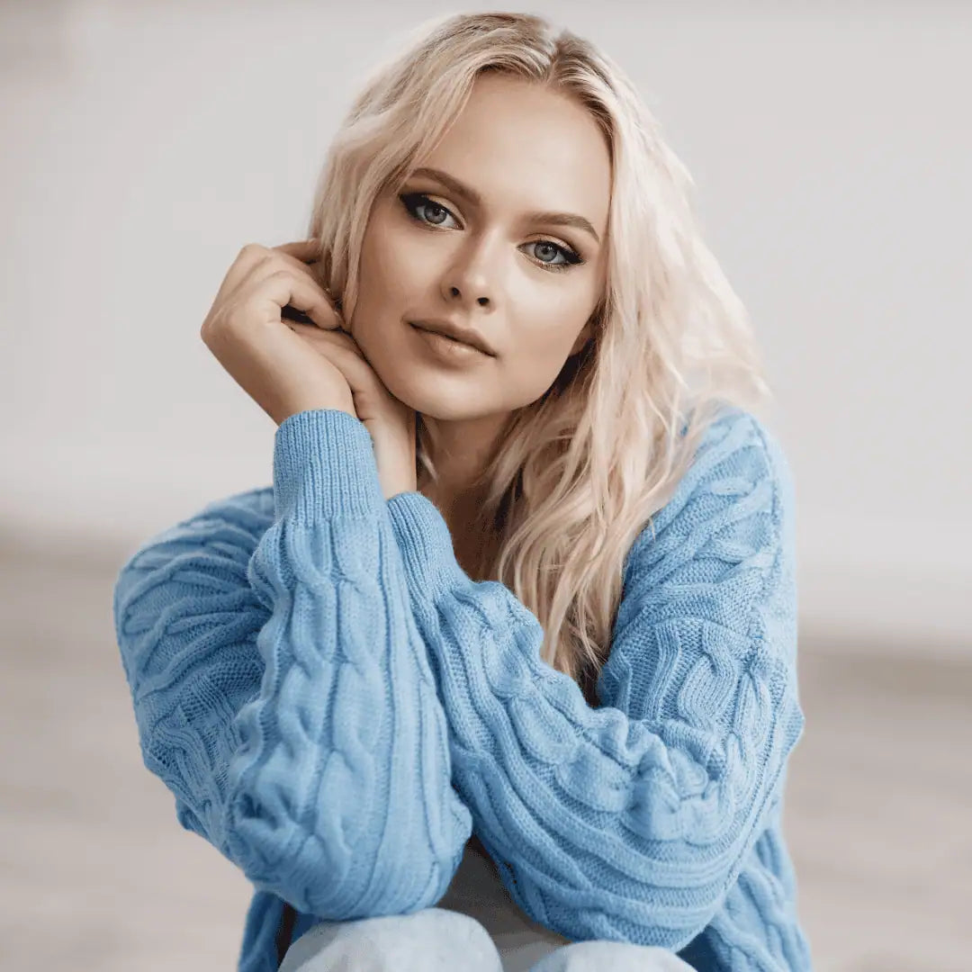 Woman wearing a blue cable knit sweater