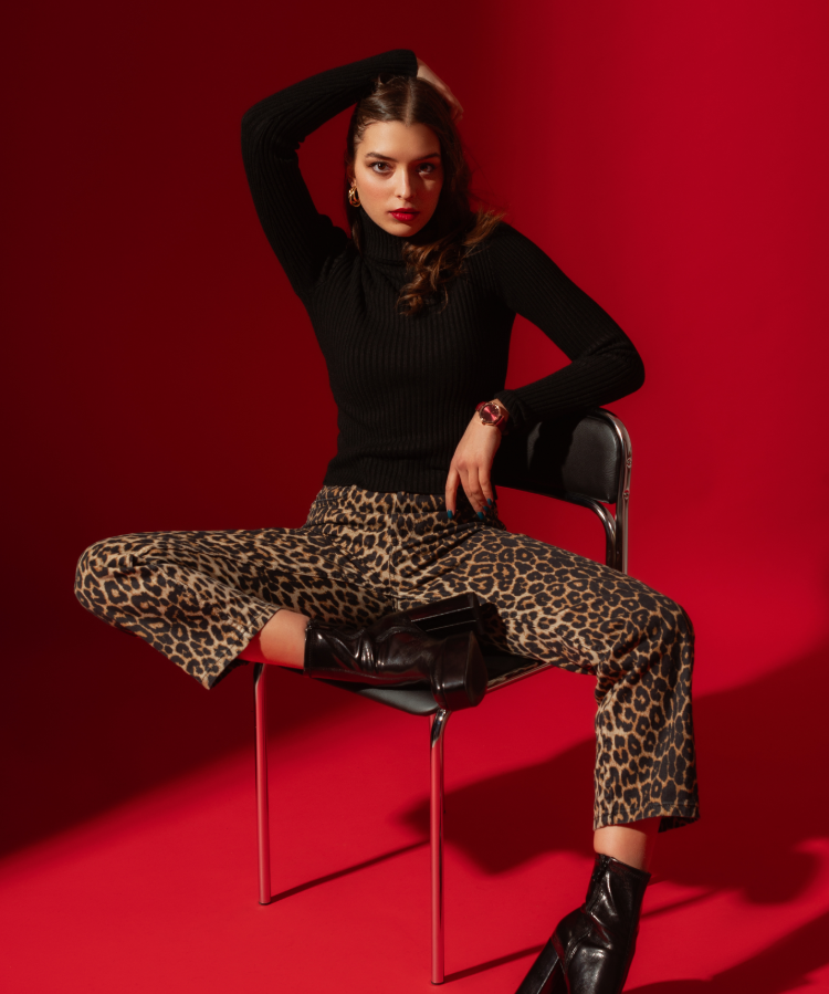 Leopard print pants with black top and boots.
