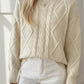 Cream-colored oversized cable-knit crewneck sweater with ribbed cuffs