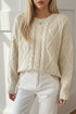 Cream-colored oversized cable-knit crewneck sweater with ribbed cuffs
