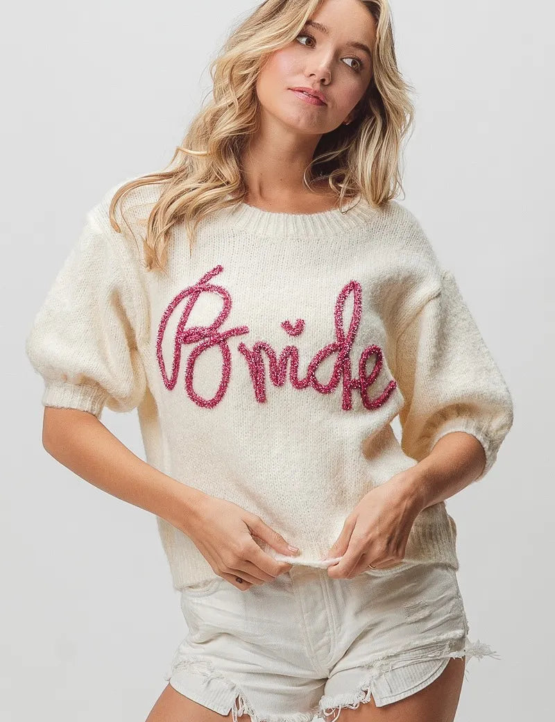 Cream-colored bride sweater with pink sequin lettering and puff sleeves