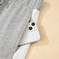 White iPhone 13 on Daverri Fashions grey sweatpants set