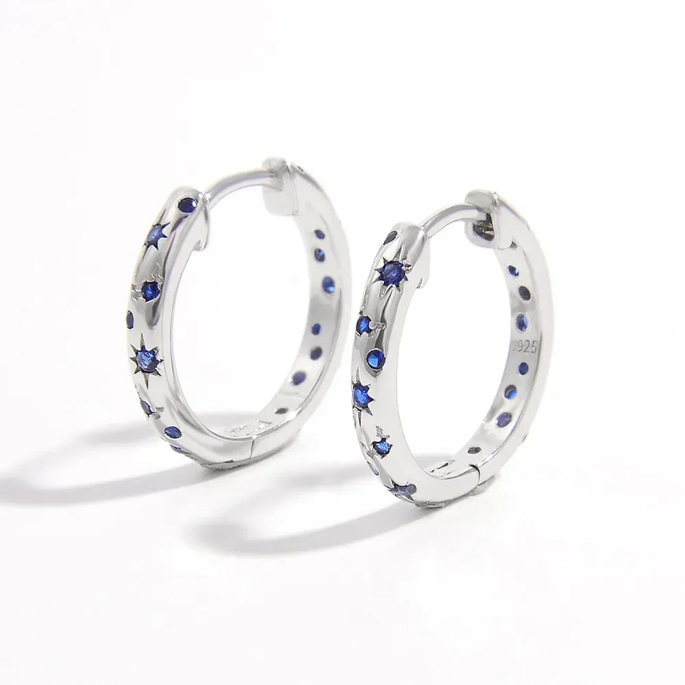 Silver star-studded huggie earrings with blue zircon gems
