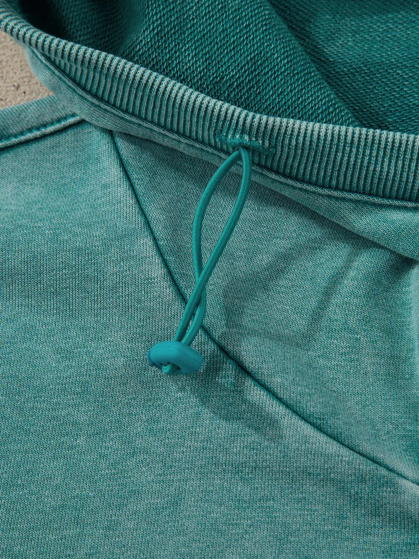 Teal drawstring hood with ribbed trim on women’s mineral wash baggy hoodie