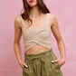 Beige crocheted crop top with thin straps on twill shorts