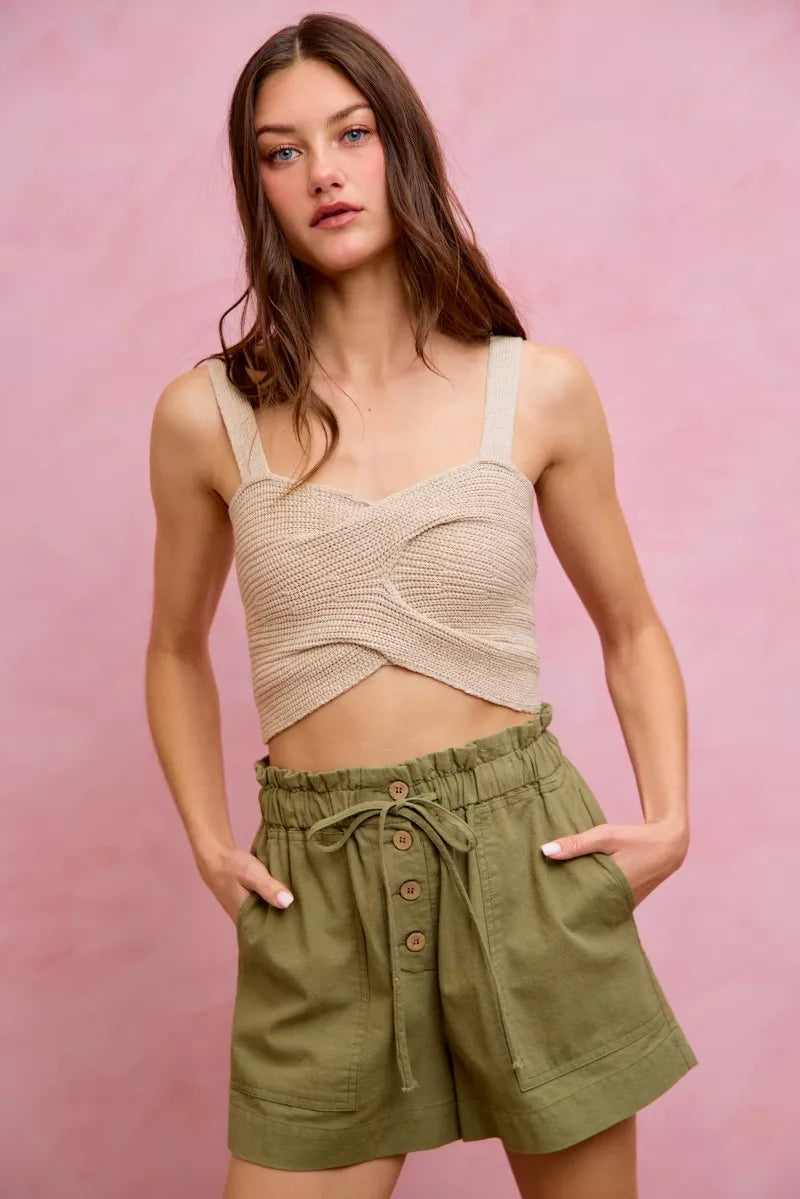 Beige crocheted crop top with thin straps on twill shorts