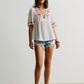 White embroidered boho V-neck blouse with red floral details and flutter sleeves