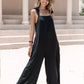 Black sleeveless wide-leg jumpsuit with tie shoulders and flowing silhouette