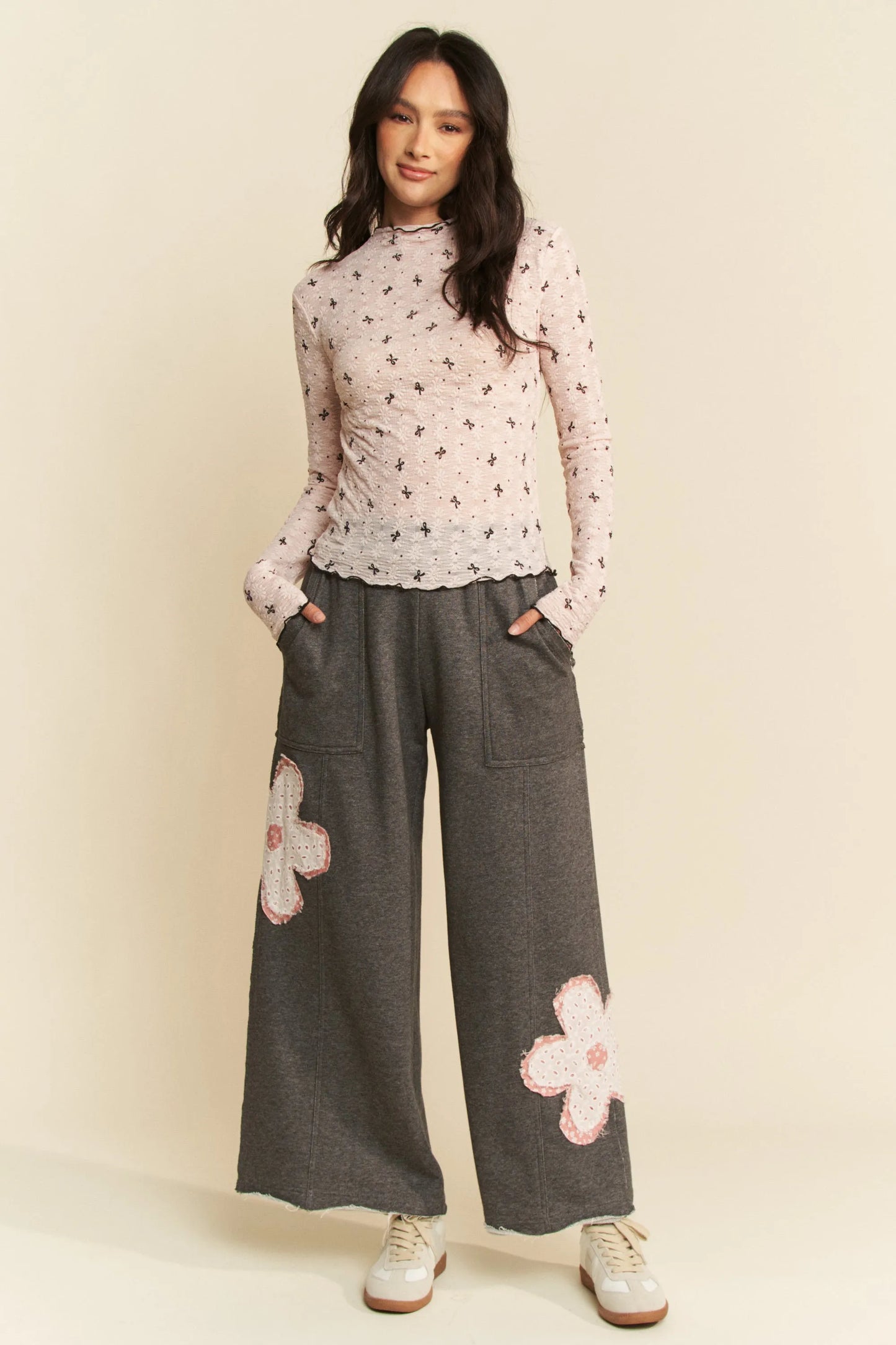 Gray wide-leg pants with pink and white floral patches on lower legs
