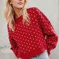 Daverri red knit sweater with white butterfly pattern and ribbed cuffs