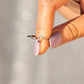 Silver ring with cz accents being held by a womans hand