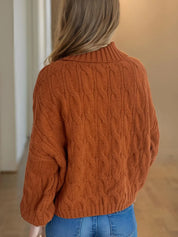 Rust-colored cable-knit turtleneck sweater with balloon sleeves
