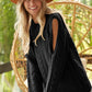 Black cable-knit BiBi Twist sweater with open shoulder cutouts