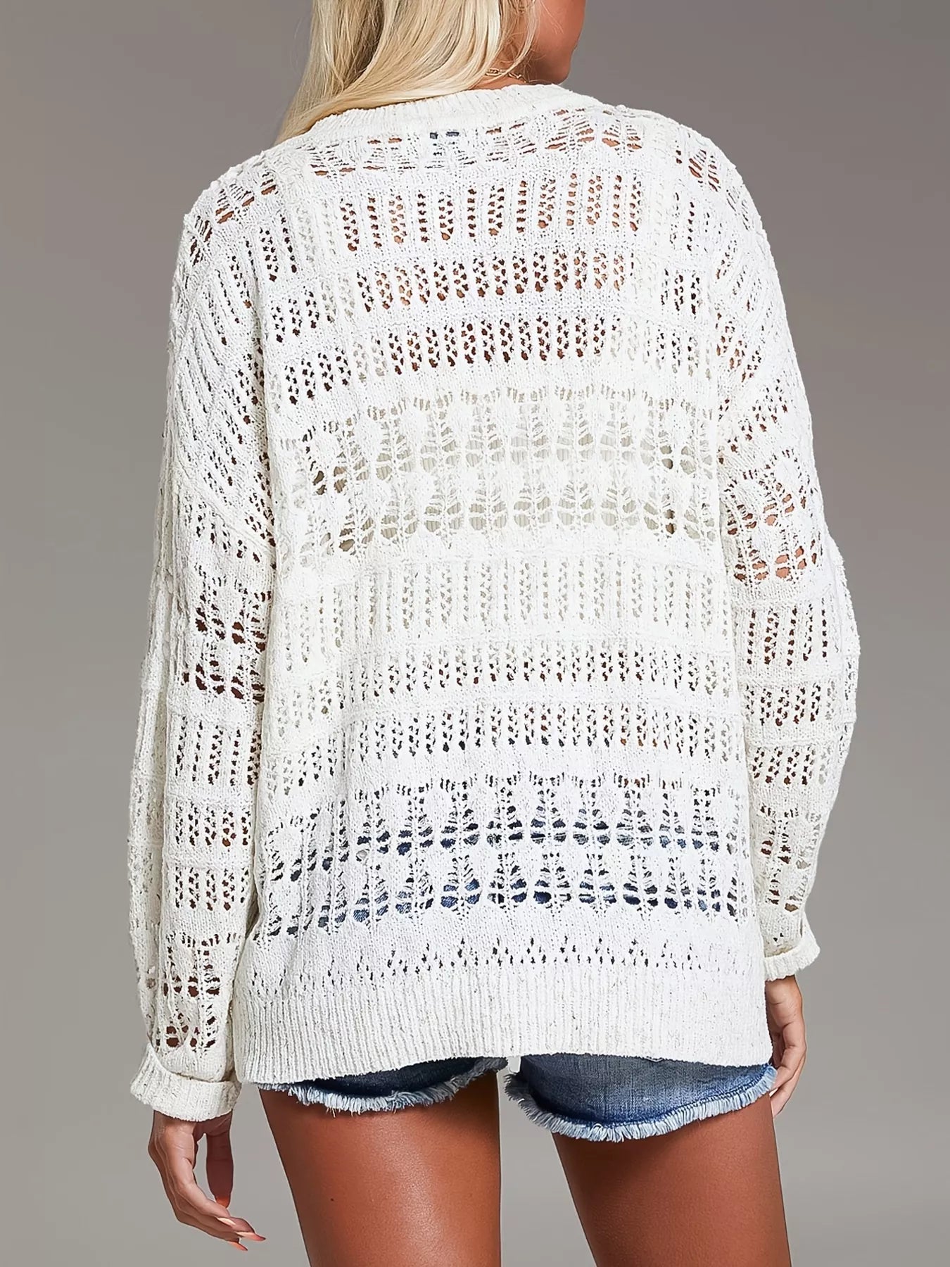 White open-knit sweater with textured pattern, ribbed cuffs and button details
