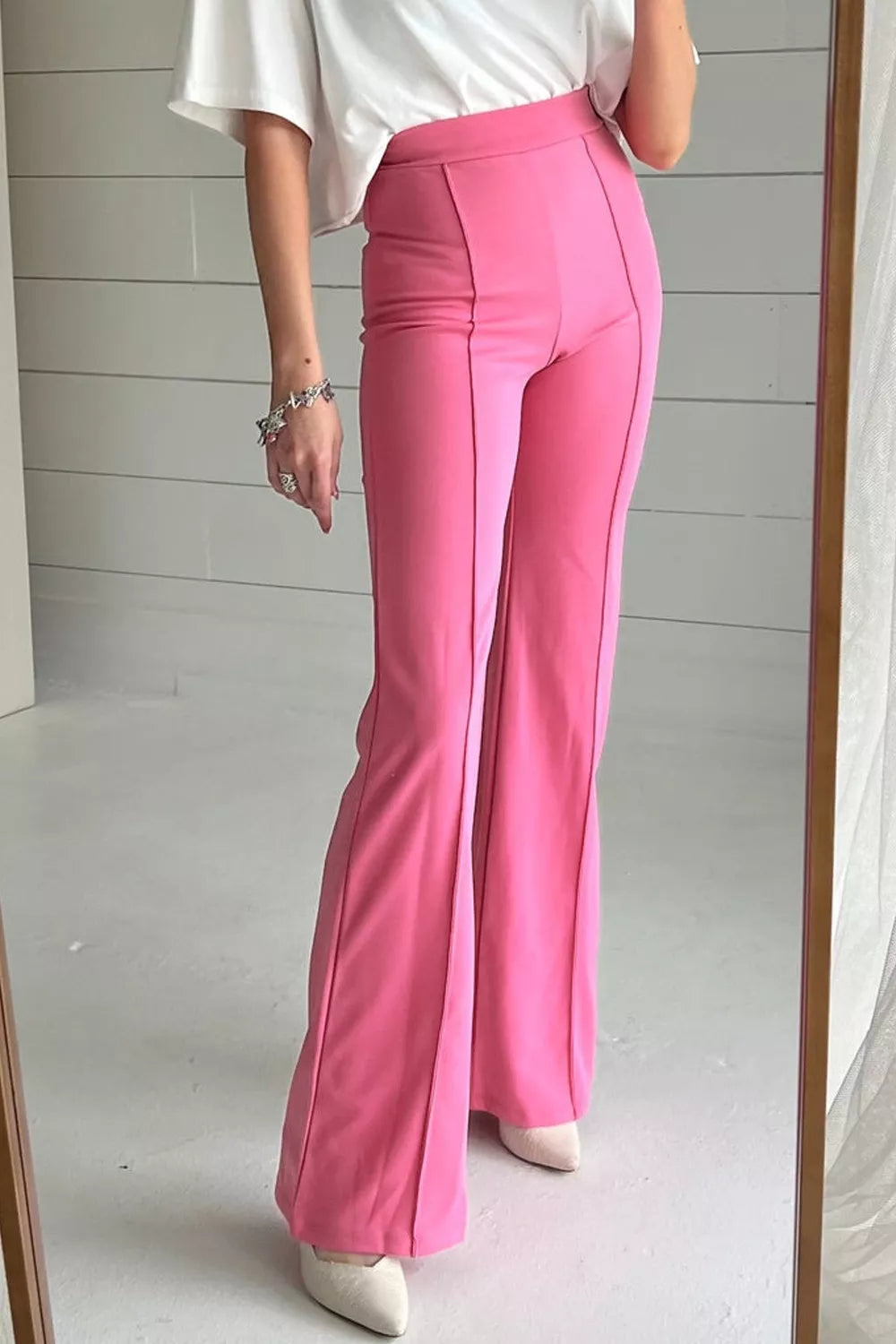 Bright pink high-waisted bootcut pants with flared tailored fit