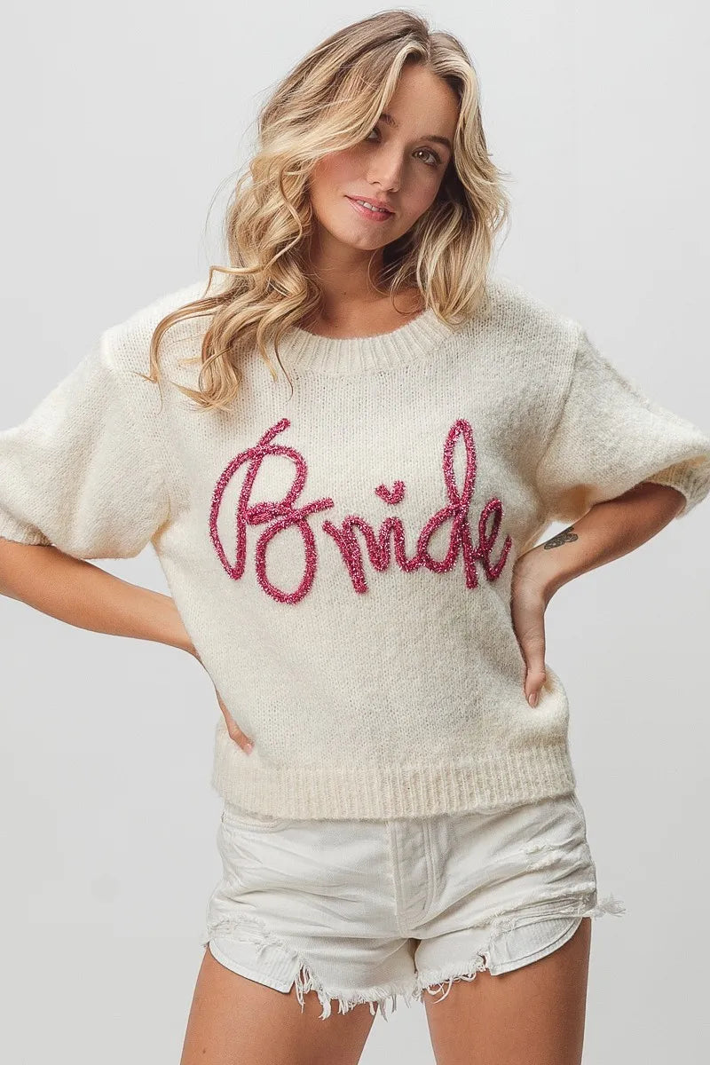Cream-colored bride sweater with pink glitter lettering and short sleeves