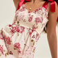 Floral tiered maxi dress in off-white with red green blossoms and ribbon straps