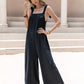 Black satin sleeveless wide-leg jumpsuit with tie shoulders and embroidered bodice