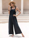 Black satin sleeveless wide-leg jumpsuit with tie shoulders and embroidered bodice