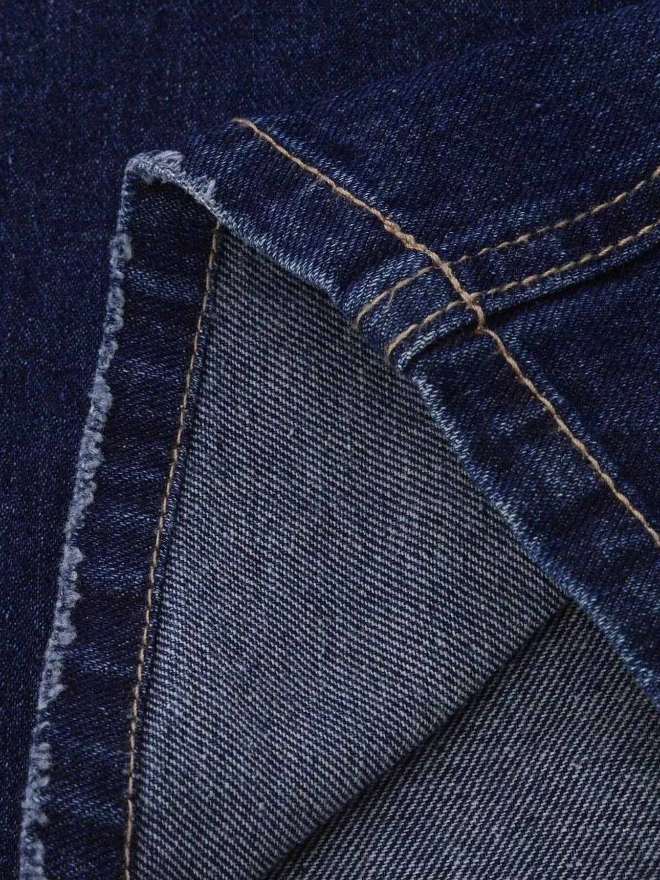 Distressed loose fit jeans in dark blue denim with stitching and frayed edge