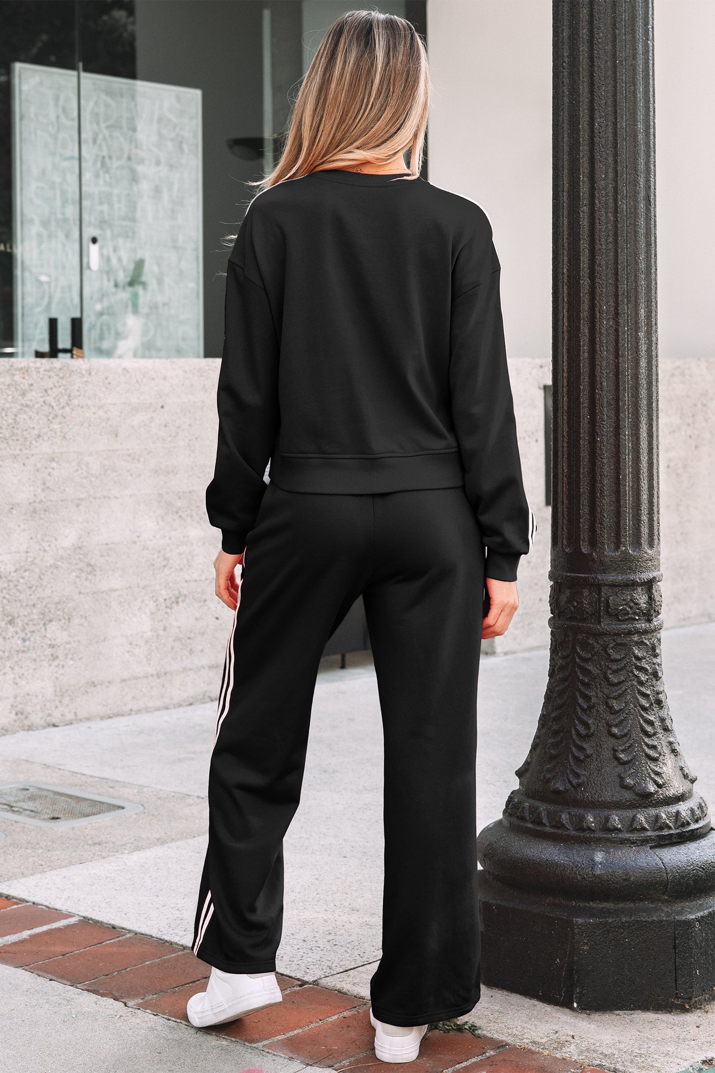 Black athletic crewneck sweatshirt with white sleeve stripes