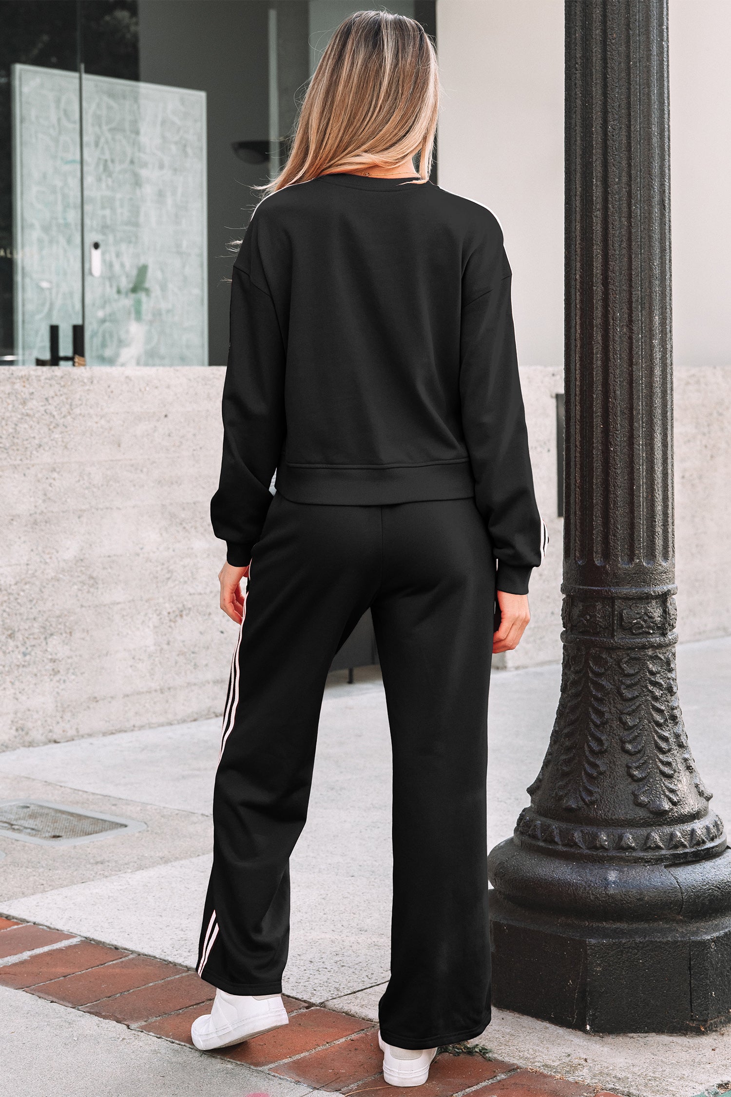 Black athletic crewneck sweatshirt with white sleeve stripes