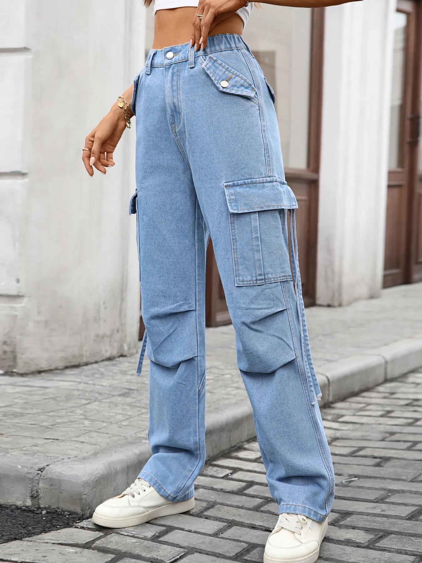 High-waisted light-wash denim cargo jeans with large pockets and straight-leg fit