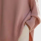 Soft pink oversized knit poncho with batwing sleeves and ribbed cuffs