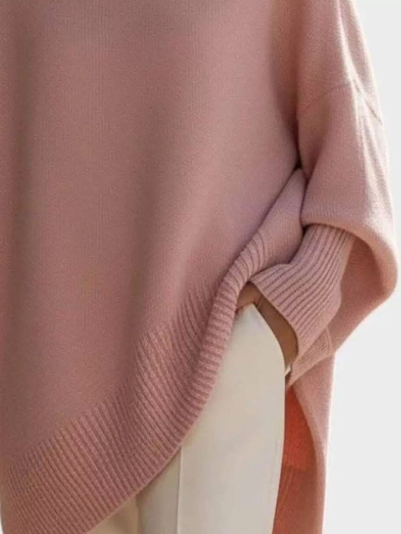 Soft pink oversized knit poncho with batwing sleeves and ribbed cuffs