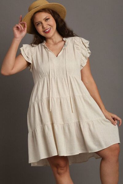 Cream ruffled tiered linen A-line mini dress with gold buttons and straw hat