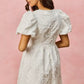 White floral jacquard mini dress with puff sleeves and fitted waist