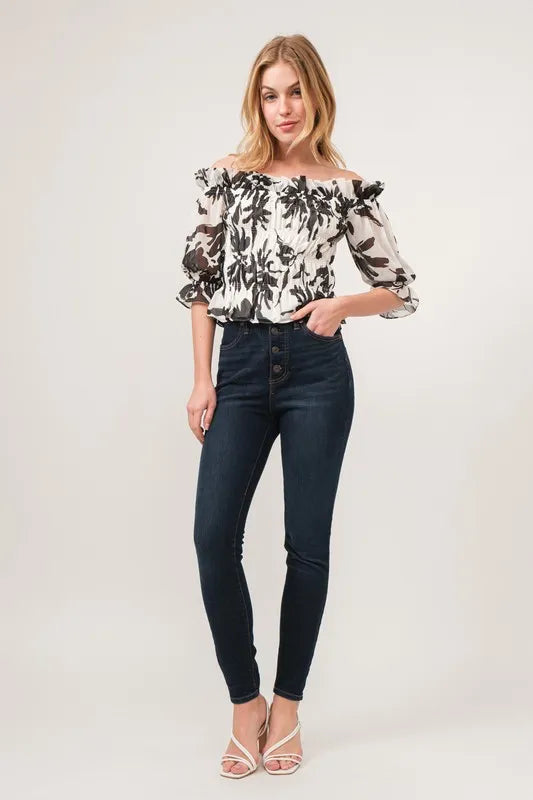 Black high-waisted jeans with button detail and And The Why smocked off-shoulder floral top