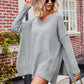 Light gray V-neck oversized sweater with slit exposed seams and ribbed cuffs