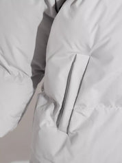 White pocketed zip-up hooded puffer jacket with silver zipper and gray piping