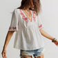 White embroidered floral V-neck blouse with red details
