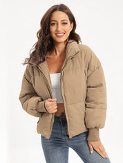 Beige oversized zip-up turtleneck puffer jacket with fur-lined hood