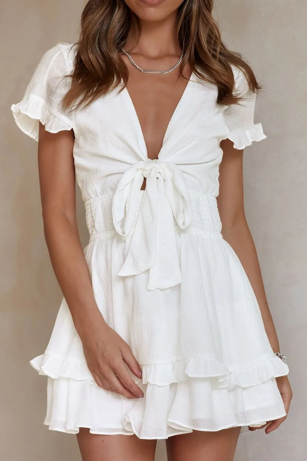 White tie-front mini dress with ruffled sleeves and smocked waist