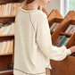 Cream-colored ribbed knit V-neck pullover with exposed gray seams
