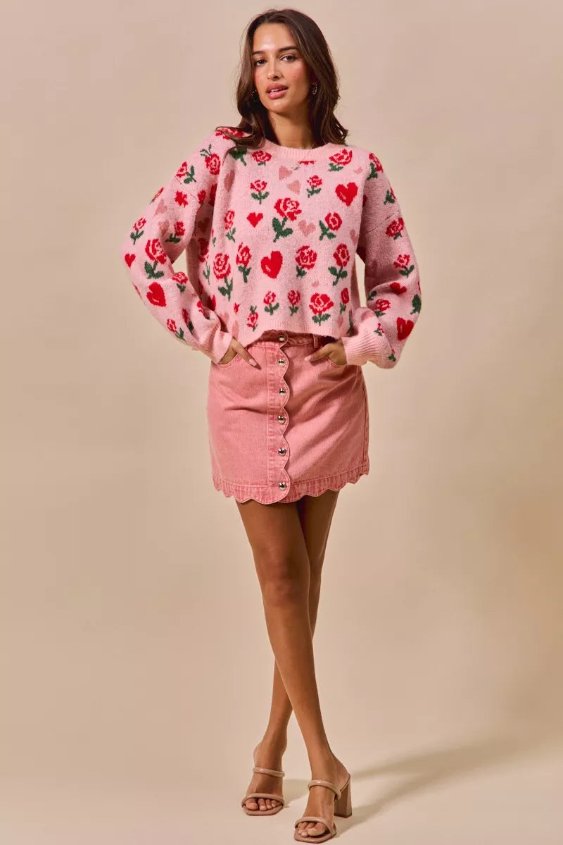 Pink sweater with red roses, hearts, and scalloped hem on denim skirt