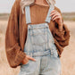 Distressed denim overalls shorts in light-wash with frayed hem and adjustable straps