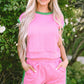 Pink textured two-piece set with green trim and drawstring waistband