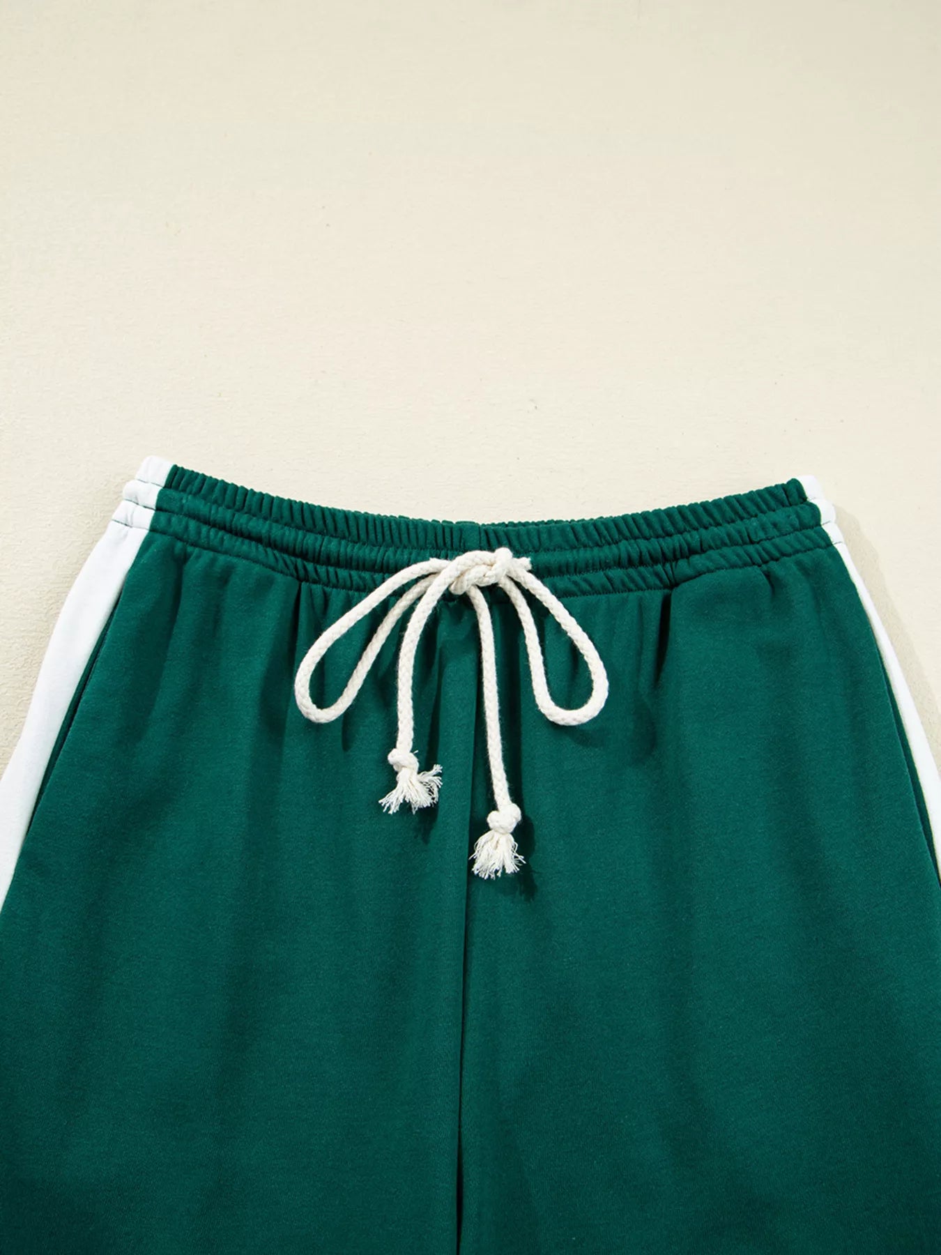 Green drawstring track pants with white stripe and tassels in set