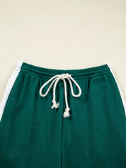 Green drawstring track pants with white stripe and tassels in set