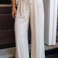 Cream-colored wide-leg drawstring pants with button details