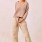 Beige ribbed knit v-neck sweater with BiBi drawstring striped pants