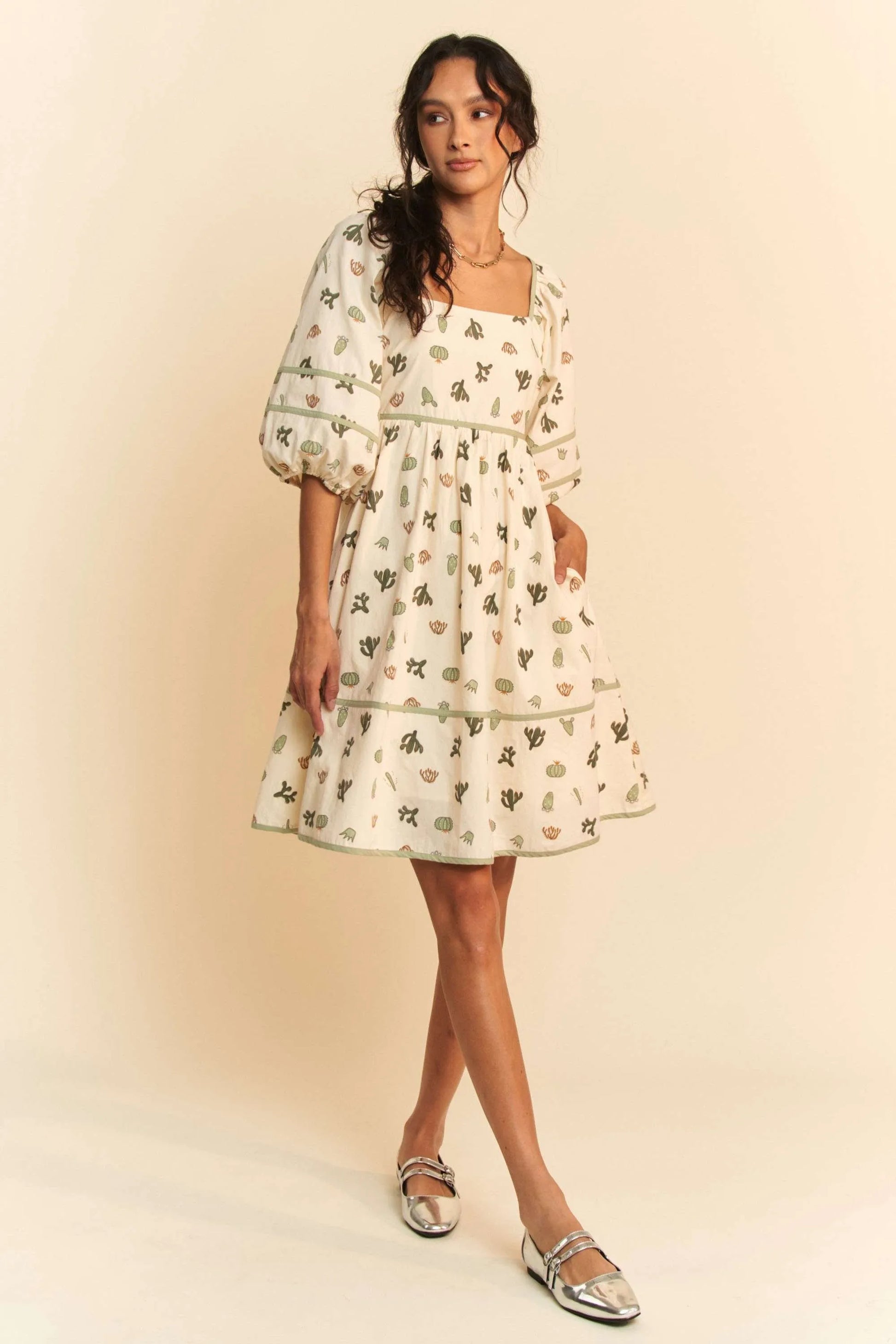 Woman in Davi & Dani cactus print poplin mini dress with puff sleeves